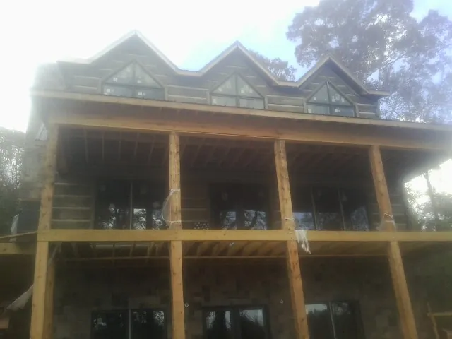 Dormers and porch framing on a large log home under construction in Iota
