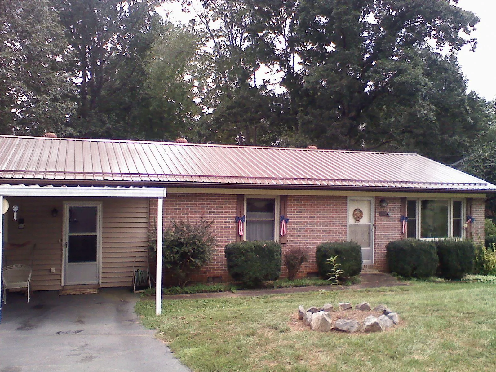 Bronze metal roof and carport on a brick ranch home — Roof Repair work by our crew in Iota